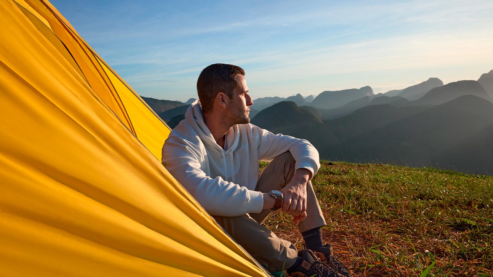 Homem acampando ao ar livre com cartão Visa Infinite
